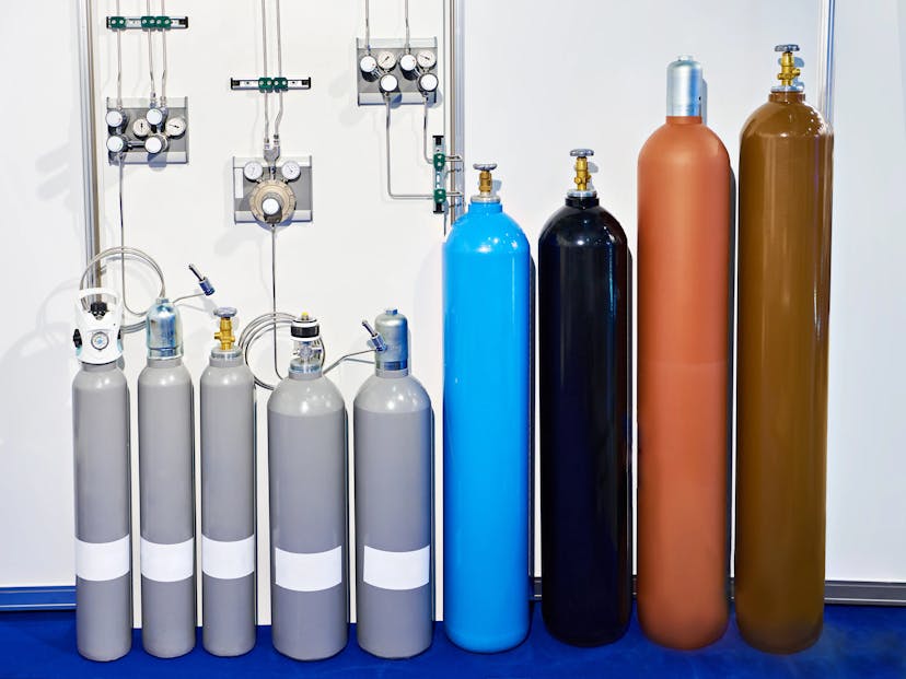 Multiple oxygen cylinders lined up for refilling, showcasing different sizes and capacities.