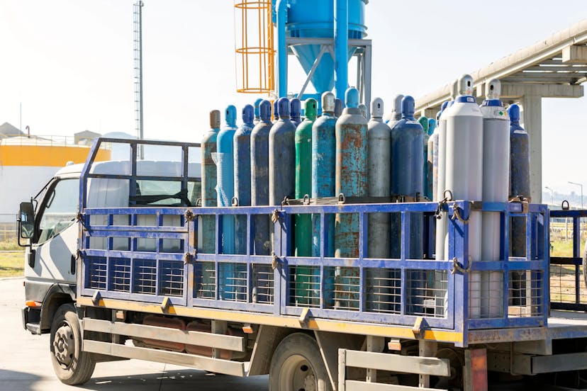 A truck carrying an array of oxygen cylinders just transported from a refilling plant.