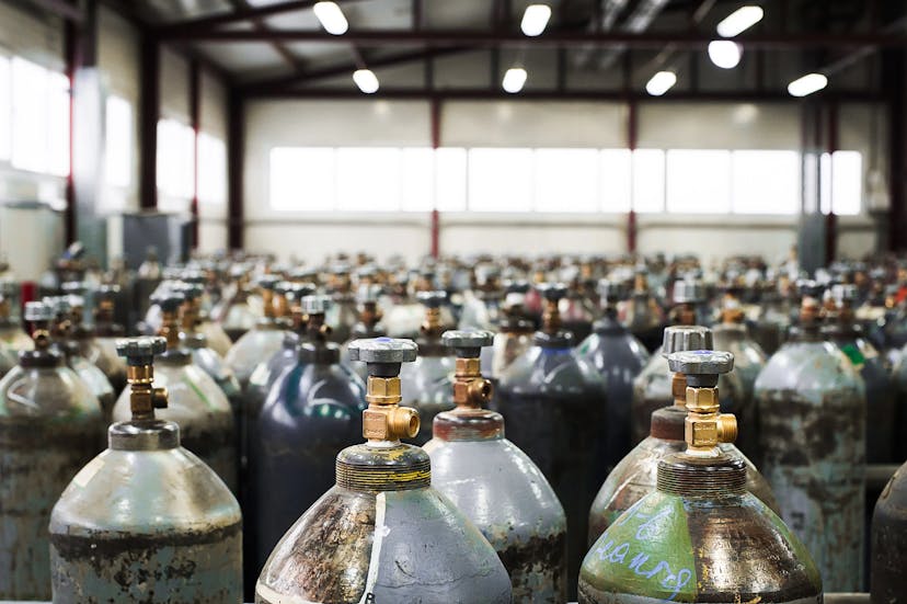 A vast collection of industrial oxygen cylinders stored in a warehouse.