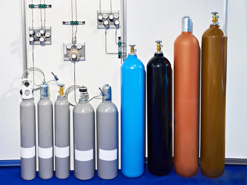 Multiple oxygen cylinders lined up for refilling, showcasing different sizes and capacities.